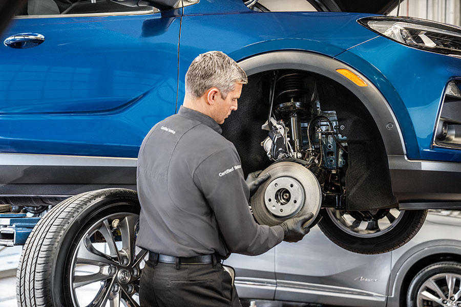Technician inspecting Chevrolet brake pads and rotor at Kirk Brothers Chevrolet of Vicksburg