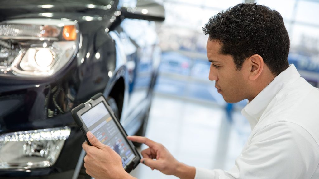 Certified Chevrolet service technician reviewing a Chevy maintenance schedule at Kirk Brothers Chevrolet of Vicksburg