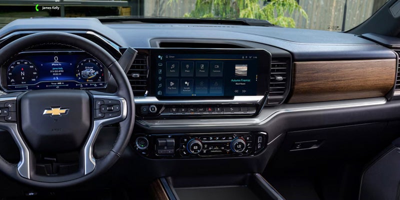 The interior dashboard and infotainment screen of the Silverado HD with wood trim