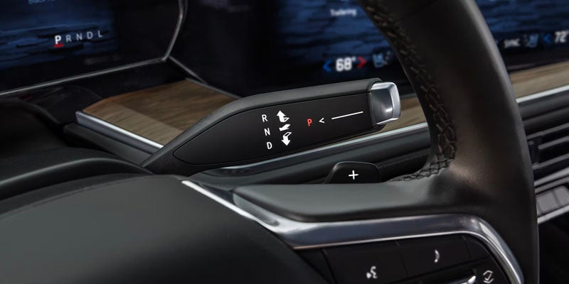 A close-up of the gear selector and wood trim on the center console