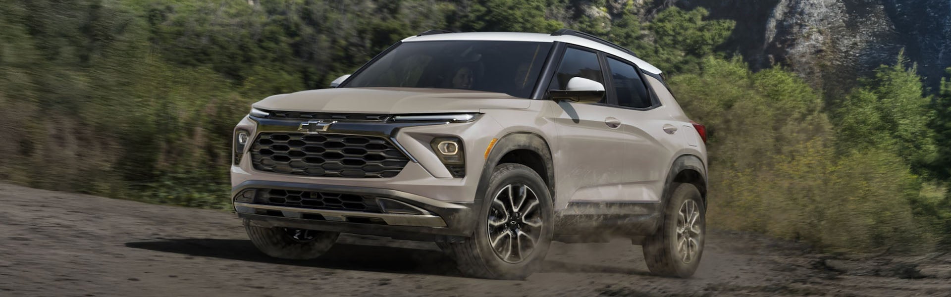 A white Chevrolet SUV, possibly a Trailblazer, driving off-road.